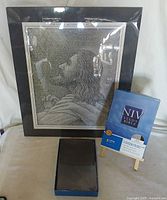 Photo showing the framed grayscale Jesus print with black matte, the Zondervan NIV Study Bible in original packaging on a small easel, and an open box next to these items.