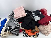 Overview of assorted fabric scraps in various colors including black, silver metallic, pink, blue, cream, red, orange, and patterned pieces.