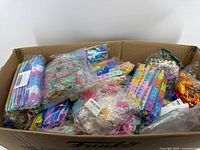 Large box filled with multiple individually packaged silicone fidget toys showing various shapes and colors