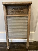 Full view of the antique Pearl wooden washboard showing the wooden frame and metal washing surface with a diamond pattern.