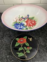 Photo of a large metal bowl and two round metal coasters with floral and bird design