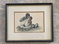 Full frontal photo of framed Indigenous print showing mother and child seated on fur, in traditional clothing.
