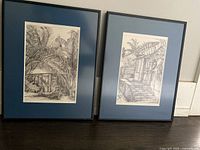 Pair of two framed black and white art prints with blue matting and black frame, signed and numbered by G. Gobinet, shown side by side