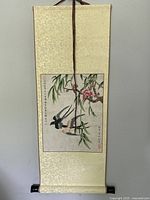 Full view of the vintage Chinese scroll mounted with cream-gold silk brocade fabric, depicting two birds, blossoming branches, and bamboo leaves.
