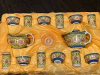 Full set of vintage Chinese porcelain tea set arranged in yellow satin-lined box showing teapot, tea cups and bowls