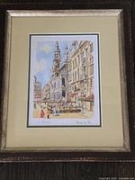 Framed watercolour artwork titled 'Maison du Rai' showing a street scene with historic buildings and flower market, signed by Y. Ziaeian.