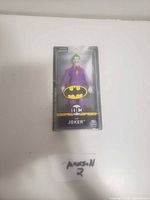 Photo of a brand new Joker figure in original sealed plastic packaging with Batman branding and DC logos.