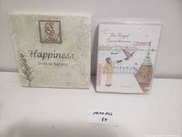 Photo showing the wall picture with the phrase 'Happiness loves to happen' next to the DVD case of The Royal Tenenbaums.