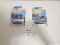 Two Batman Hot Wheels cars in original packaging, front view showing designs and branding