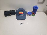 Photo of all items together: sunglasses case, hat, tall Halloween mug, small Halloween dish mug