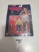 Front view of Mike action figure in original Stranger Things packaging showing figure and accessories.