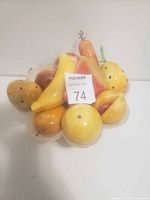 Front view of vintage alabaster fruit collection placed in dish showing variety of carved fruits including banana, pear, apple, and watermelon slice.