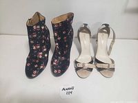 Two pairs of women's shoes: black floral ankle boots and beige and black heeled sandals, displayed together