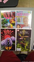Four comic books: The 'Nam, Legendary Star-Lord, The Maxx, and The Immortal Iron Fist on a flat surface, showing colorful cover art.