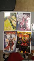 Photo of four comic books: Silver Coin, Napalm Lullaby, Stranger #1, Iron Man