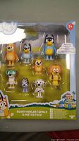 Photo showing the sealed Bluey Heeler Family & Mates figure set with nine plastic character figures visible in original packaging.