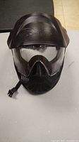 Front view of black paintball mask showing visor and ventilation