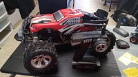 Side view of the red and black RC car showing design and included remote controller.