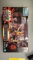 Photo of the unopened Star Wars Mos Espa Encounter figure set in original packaging, with visible Darth Maul key fob.