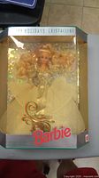 Photo of vintage Barbie Crystalline doll sealed in original box with yellowed packaging and decorative holographic holiday theme.