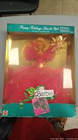 Photo of the vintage Barbie doll sealed in original box, showing the Barbie dressed in pink gown holding star wand with holiday packaging.