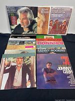 Photo showing multiple vintage country vinyl records arranged side by side including Kenny Rogers, Glen Campbell, Anne Murray, Connie Francis, and Johnny Cash albums.