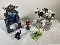 Front view of all six Transformer figures including Trypticon, Fortress Maximus-like figure, and four smaller figures.