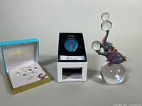 Three Disney collectible items shown: Dumbo figurine, Lilo & Stitch watch in box, and an open box of Disney silver plated earrings.