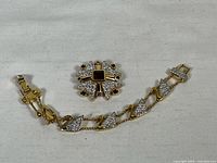 Full view of the Swarovski bracelet and brooch on a fabric surface, showing the design and clasp of the bracelet and the brooch shape.