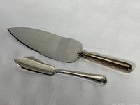 Butter spreader and cake cutter displayed side by side showing full length and design details.