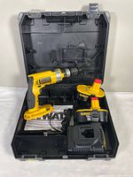 DeWalt drill driver hammer with charger, battery, case, and manual inside carrying case