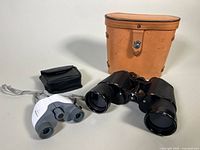 Telstar and Hammer’s binoculars front view with respective cases, showing sizes and storage cases.