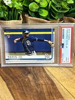 Front view of 2019 Topps Fernando Tatis Jr rookie card in graded PSA 9 plastic case, showing player in San Diego Padres uniform fielding a ball.