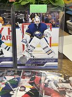 Young Guns hockey card of Devon Levi in Buffalo Sabres uniform, goalie position with protective equipment.