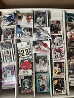 Top down view of various baseball and hockey sports cards showing patches, autographs and player images