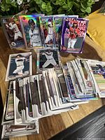 Multiple Bowman baseball rookie cards laid out on a table, showing holographic, refractor, and color variants with players in different MLB team uniforms.