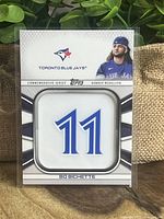 Front of Bo Bichette jersey number medallion card featuring number 11 and player image against a decorative background.