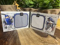 Two Toronto Blue Jays Museum Collection booklet jersey baseball cards featuring Edwin Encarnacion and Brett Lawrie with jersey swatches in the cards.