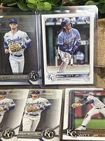 Front display of five Bobby Witt Jr baseball cards with Kansas City Royals uniform in protective sleeves, showing multiple poses including fielding and batting.