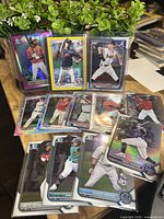 Photo showing 12 assorted Bowman Chrome baseball cards featuring Evan Carter, Chris Amador, Raffy, Chris Vallimont, and others in various refractor and 1st Bowman parallels.