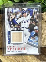 Front of Freddie Freeman 2026 Topps card showing player image and game-used bat wood piece.
