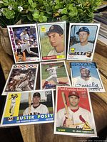 Photo of nine baseball rookie cards arranged on wooden surface, featuring players including Don Mattingly, Carl Yastrzemski, Carlton Fisk, Buster Posey, Paul Goldschmidt, Bo Jackson, and others.