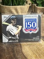 Front view of the Lou Gehrig commemorative baseball card with 150 years patch encased in plastic.