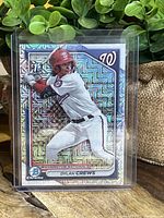 Front of Dylan Crews 1st Bowman Chrome Mega prospect baseball card with holographic geometric pattern background and Washington Nationals logo.