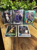 Overview of all five cards displayed on a table with greenery in background.