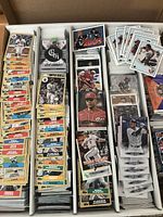 Large box with multiple rows of assorted sports cards including baseball and hockey legends and rookies.