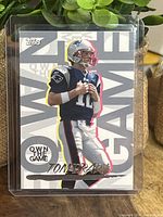 Front of 2008 Topps Own The Game Tom Brady football card showing player image and branding.