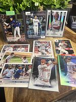 Full view of 10 Shohei Ohtani baseball cards from Angels and Dodgers teams displayed on a surface with greenery background.