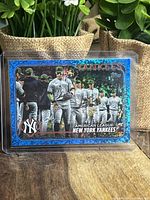 Front view of the Aaron Judge baseball card with holographic blue crackle border and image of Judge and teammates on the field.