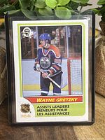 Front of Wayne Gretzky 1985-86 O-Pee-Chee Assists Leaders hockey card showing player image and card title.